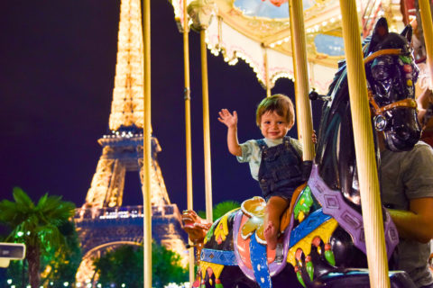 Best Things to Do In Paris With Kids featured by top US family travel blog, Local Passport Family: image of a toddler on a carousel by the Eiffel Tower