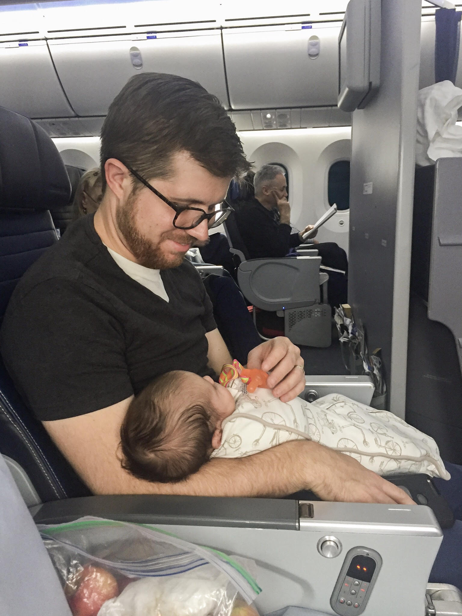 newborn with dad on aircraft in bulkhead