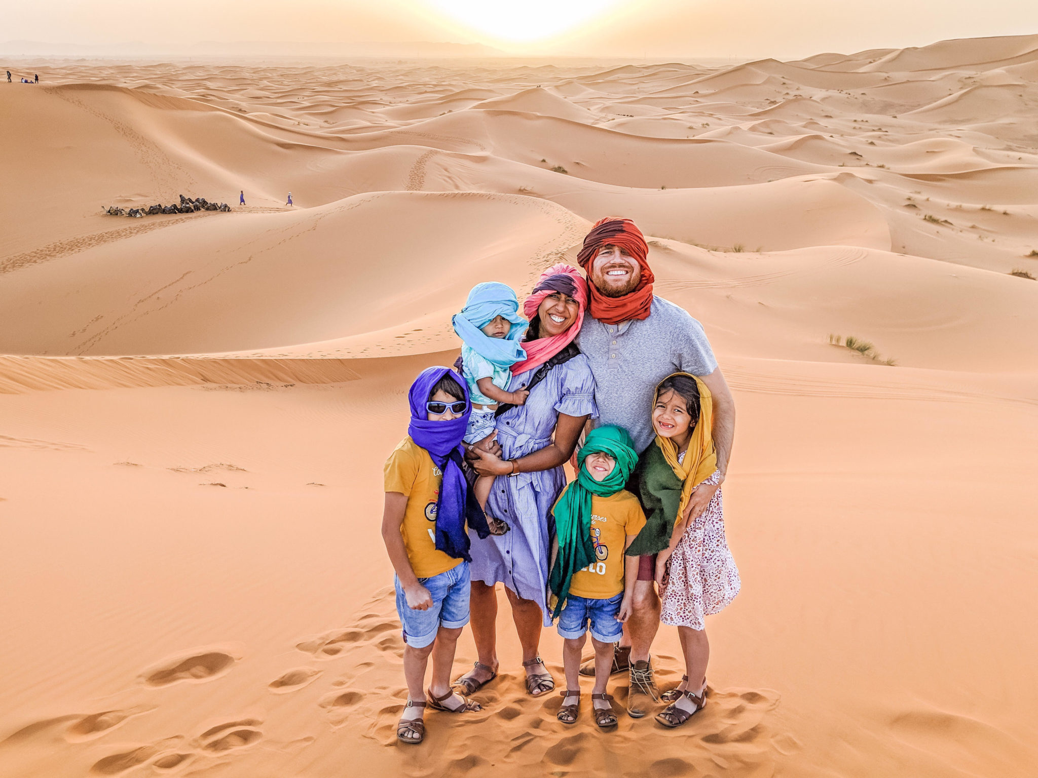 sahara desert morocco family holiday | 7 Reasons to Take a Morocco Family Vacation by popular Northern California travel blog, Local Passport Family: image of a family standing together on a sand dune in the Sahara Desert.