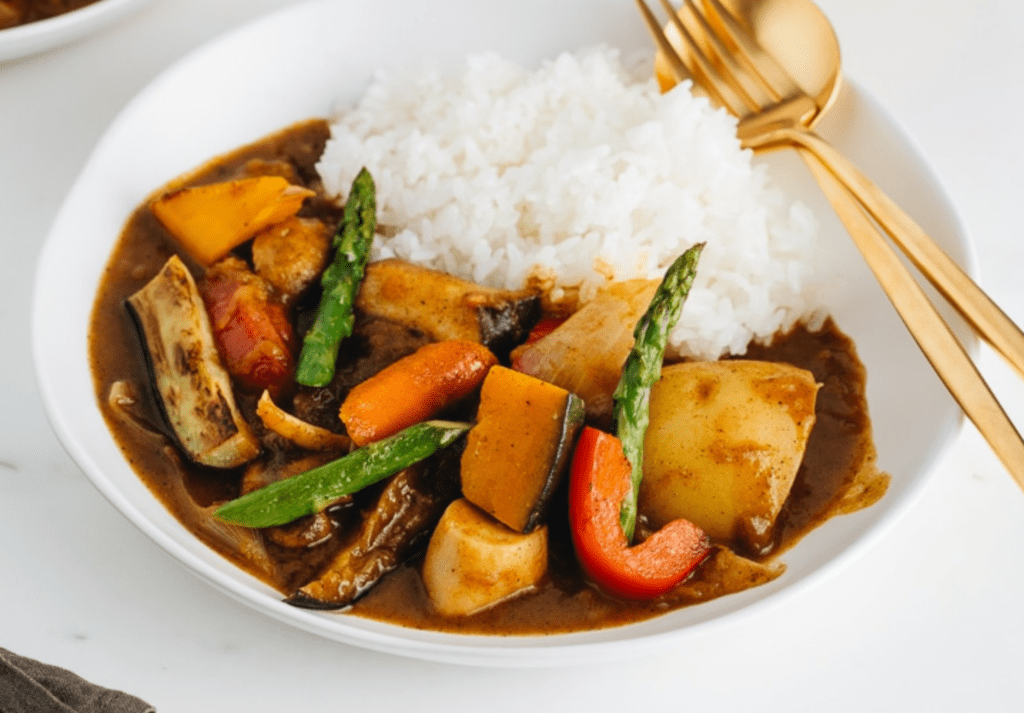 Vegetarian Japanese curry recipe in bowl with rice and silverware